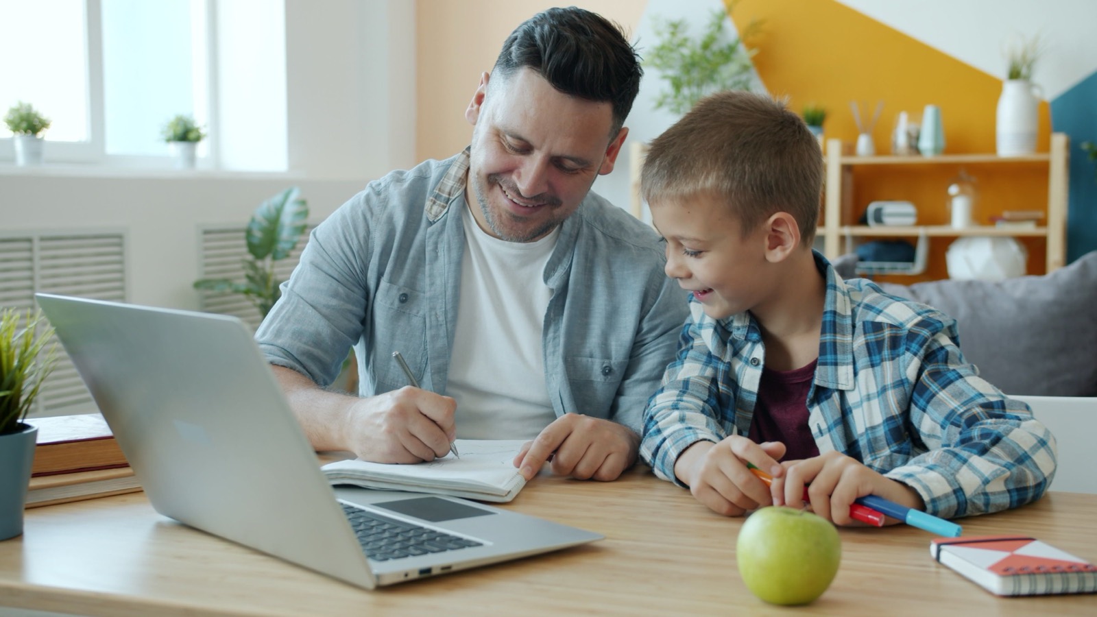 Father helping his son with homework at home